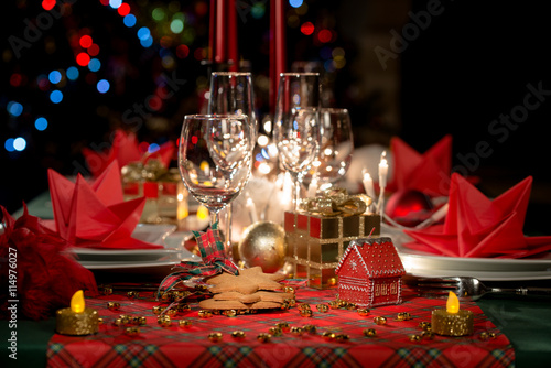 金色和红色的圣诞餐桌装饰与昏暗的烛光