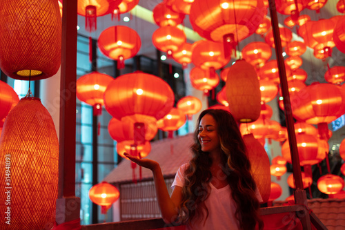 快乐的女游客在享受为中国春节装饰的传统红灯笼。Cultur