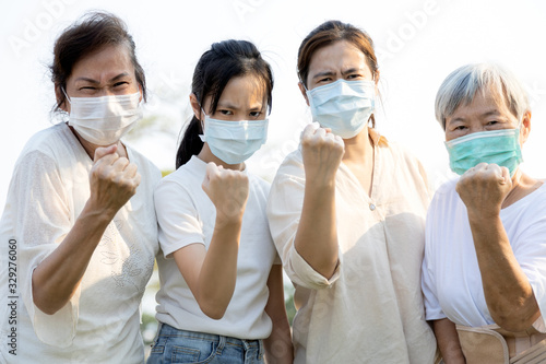 一群人戴着医用口罩，以防止感染Covid-19的传播，亚洲家庭ra