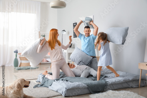 幸福的家庭在卧室的枕头上战斗