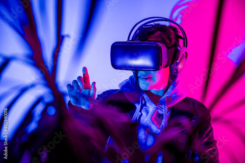 一名女子戴着虚拟现实眼镜在虚拟现实中互动，享受着虚拟世界。