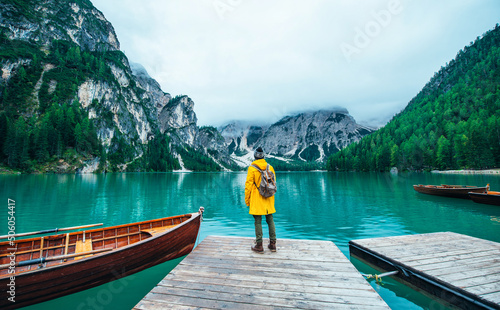 山的故事。快乐的背包客在一个旅行的假期。一个穿黄色雨衣的男人站在里面